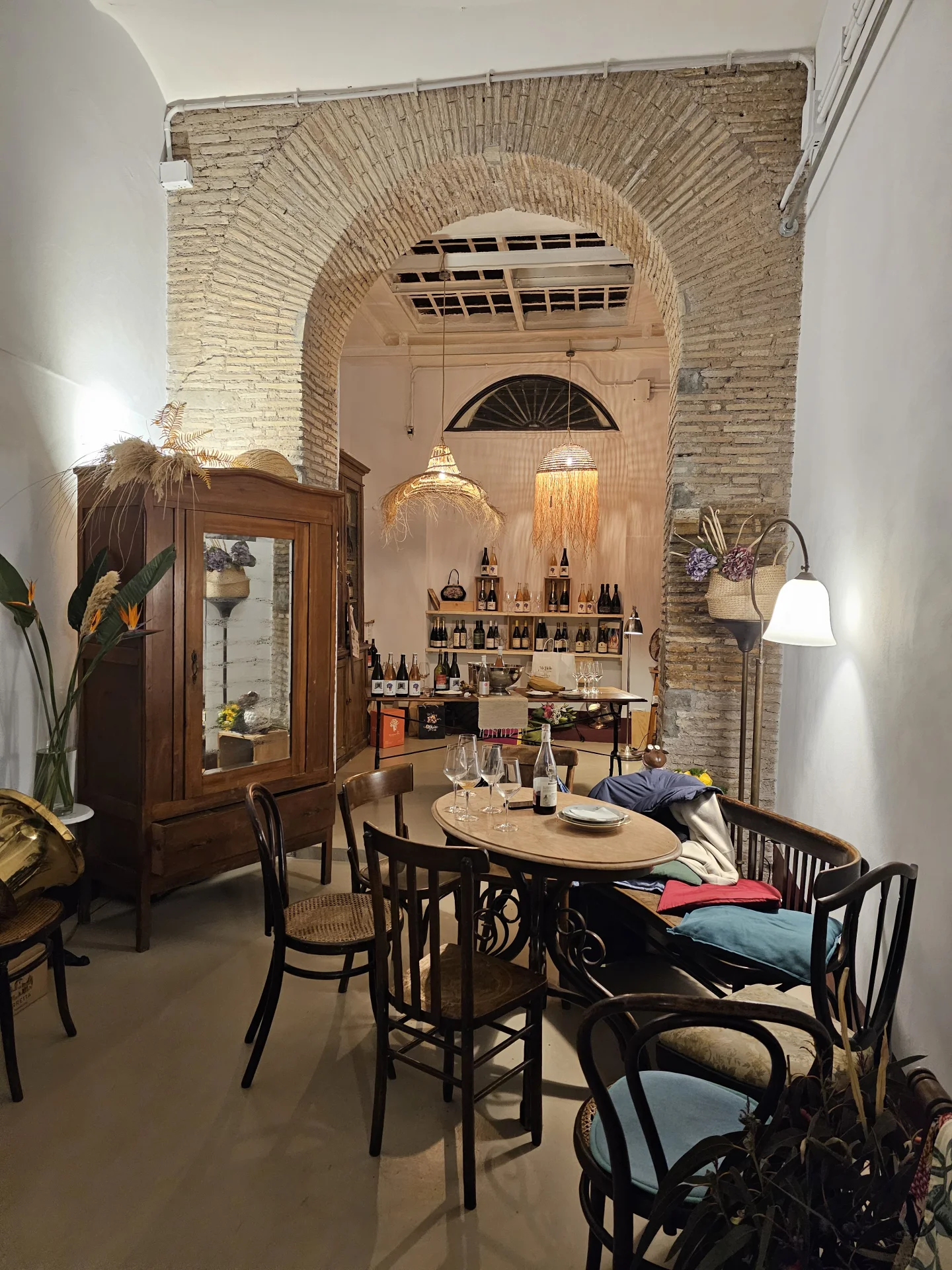 Il salotto di Accanto con arco in mattoni e tavolo rotondo.