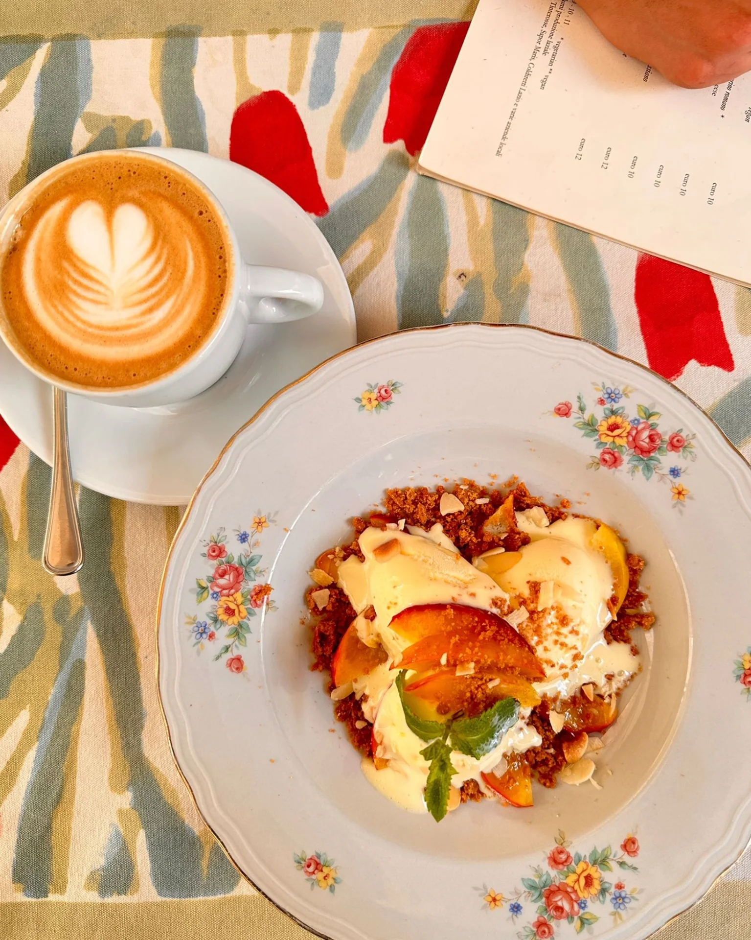 Cappuccino con latte art e dessert con pesche e crema – colazione al Caffè Novecento Roma